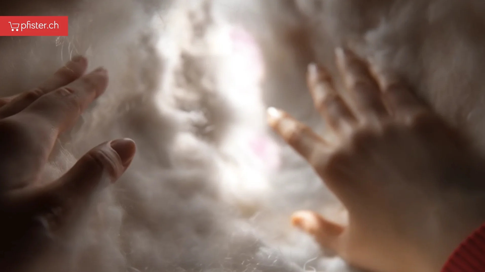 Pfister setzt hybride Produktion um. Hände die durch weichen Stoff von innen nach außen greifen.